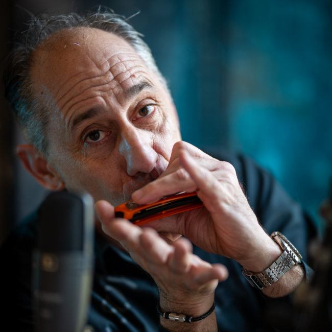 Harmoniciste homme jouant avec un harmonica orange