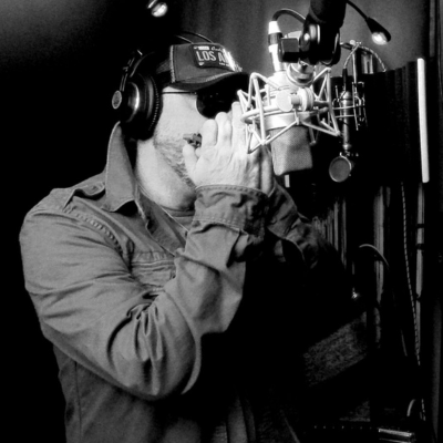 David Little Jack Photo en noir et blanc de David Jacomino jouant de l'harmonica en studio